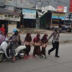 BRIPKA RANGGA RASPATI ANGGOTA UNIT BM SATLANTAS DAMPINGI KAPOLRES METRO BEKASI BERIKAN KENYAMANAN PADA WARGA MASYARAKAT DAN PARA PELAJAR YANG HENDAK MENYEBRANG JALAN DALAM GATUR LALIN DI PERAPATAN PASIR GOMBONG