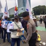 Aksi Simpatik, Polisi Bagikan Air Mineral dan Roti kepada Buruh di Depan DPR – MPR